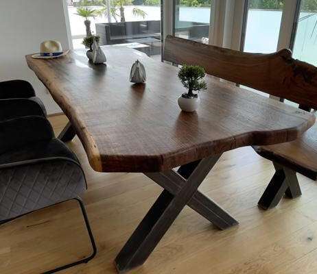 Natürliche Pflege für Terrassenholz – langlebige und umweltfreundliche Lösung Holzterrasse mit geflochtenen Sitzmöbeln und Pflanztopf in der Sonne, symbolisch für nachhaltige Holzpflege